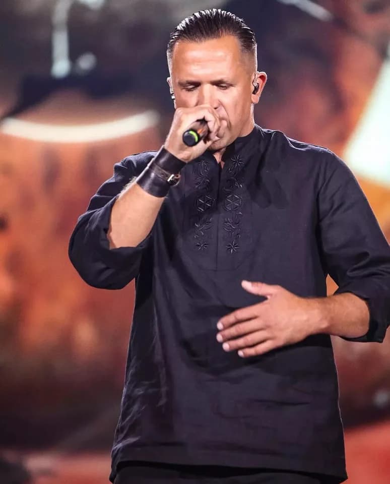 Artysta w koszuli Folk Club na scenie