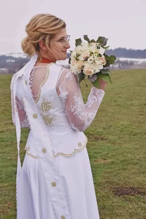 Panna młoda w sukni ślubnej Folk Club z bukietem
