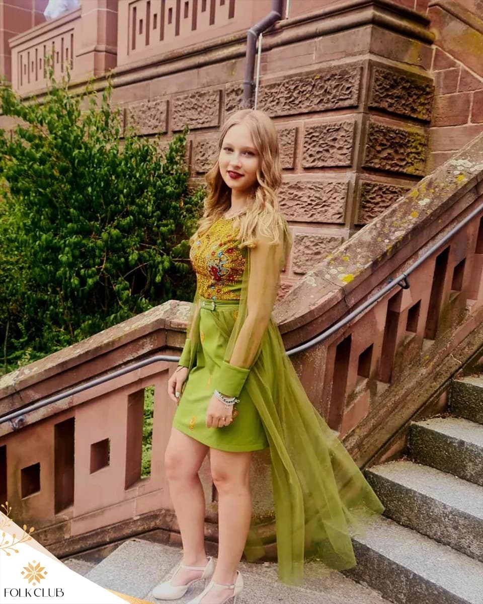 Klientka Folk Club w zielonej sukience na schodach